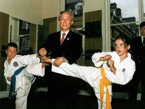 General Choi Hong Hi supporting two young students holding side kicks