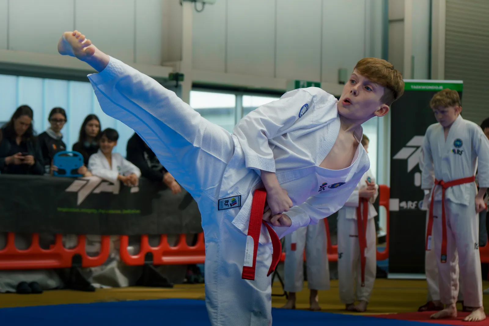 Young ITF Taekwon-Do student performing a high flying kick