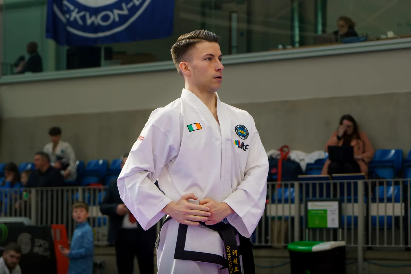Black belt athlete standing ready in a national squad dobok